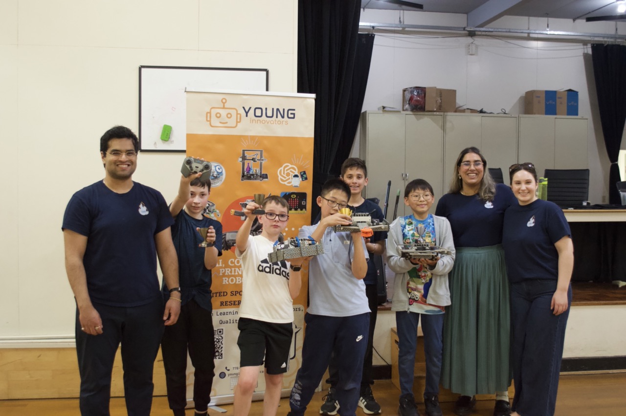 Kid posing with their trophies after a robotics competition.